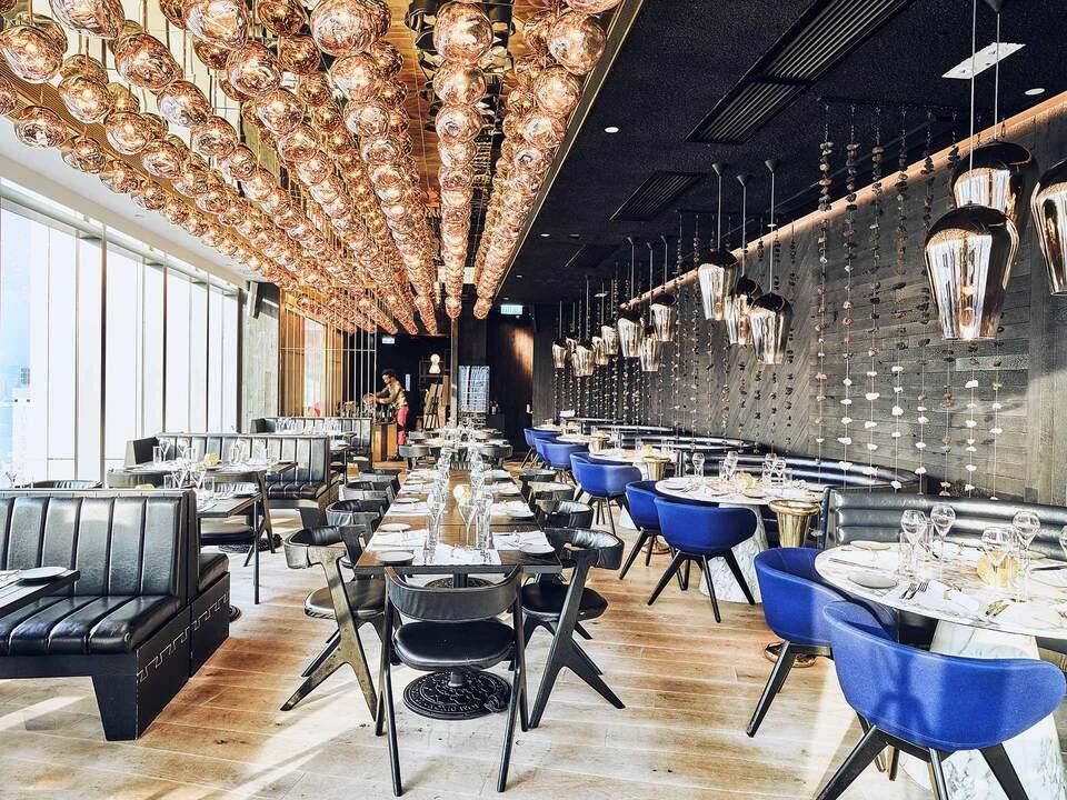 Elegant restaurant dining area with modern ceiling lights and neatly arranged tables