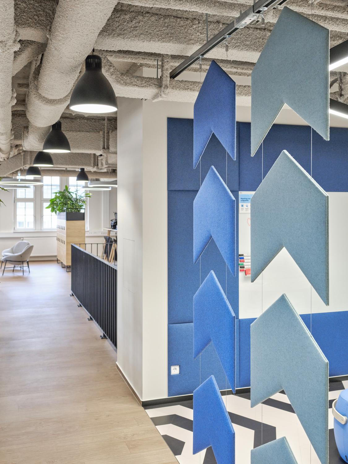 Office corridor with decorative blue acoustic wall panels in geometric design